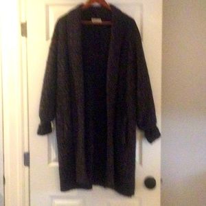 Long black sweater with multicolor stitches.